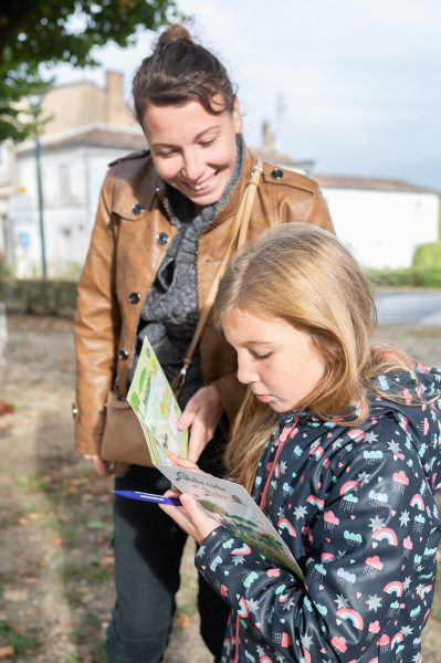 une petite fille et sa maman regardant un dépliant touristique