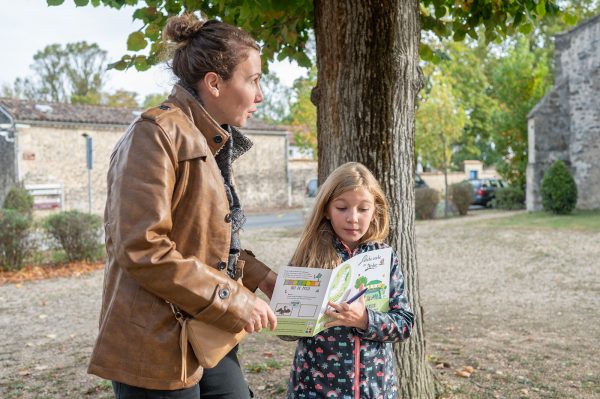 petite fille et sa maman regardant un dépliant touristique