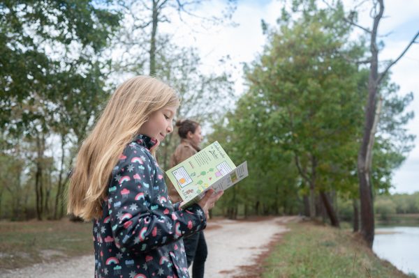 petite fille regardant un dépliant touristique aux étangs d'Avensan