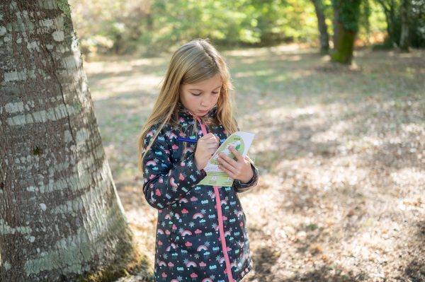 une petite fille regardant un dépliant touristique