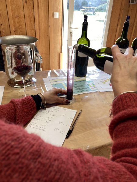 Main de femme versant du vin dans une éprouvette