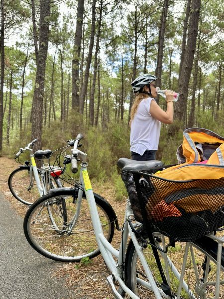 Sabine fait une pause pour boire de l’eau lors d’une balade à vélo en forêt.