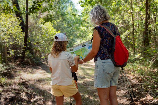 une maman et sa fille de dos sur le sentier d'interprétation Le Porge