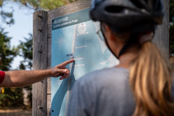 famille devant un panneau de piste cyclable du Porge en gironde