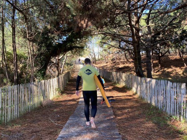 surfer qui monte la dune au Porge Océan